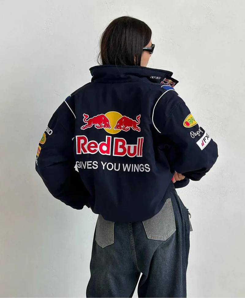 Model wearing navy Red Bull jacket on street, front view